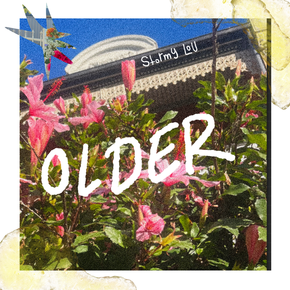 Single cover art for Stormy-Lou's "OLDER" featuring handwritten white title text over pink hibiscus flowers and historic architecture.